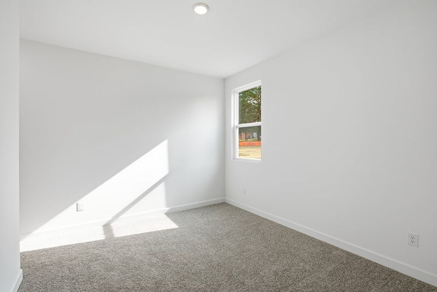 A room with a window and a carpet.