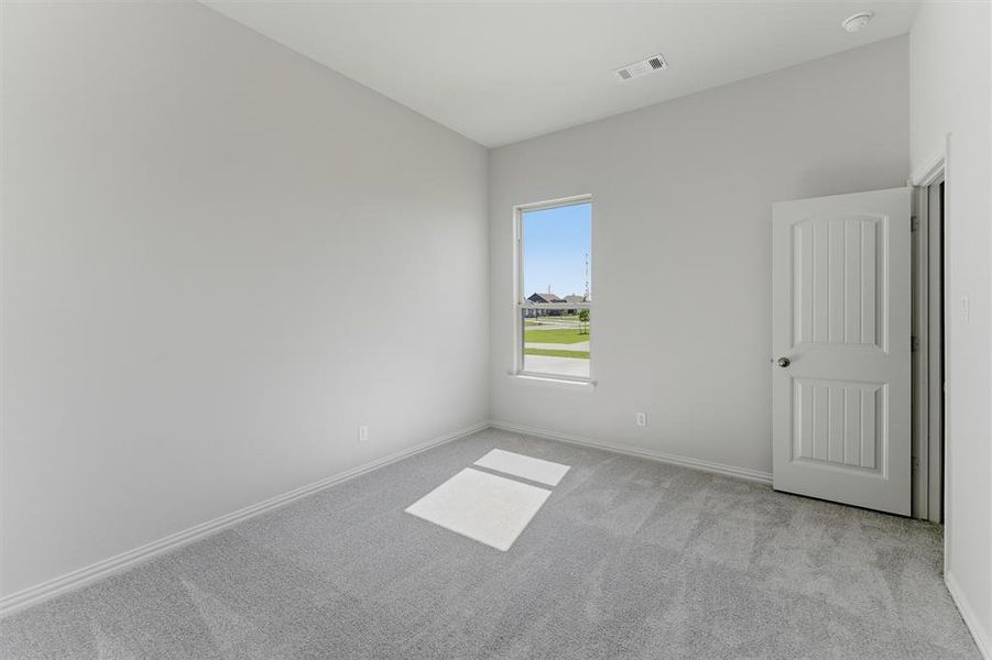 Interior room featuring light gray carpeting, white baseboards, and a single window offering exterior views