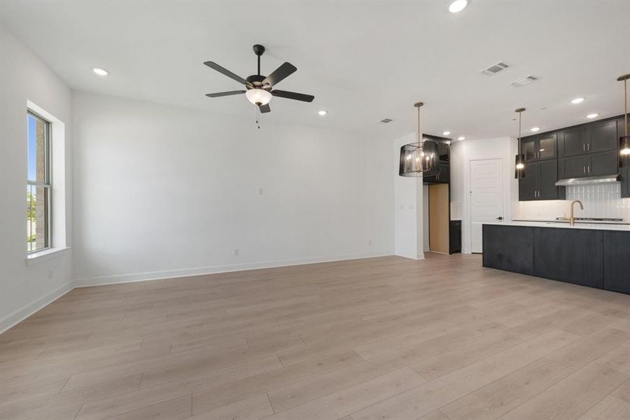 Expansive room featuring light wood-finish flooring and recessed lighting Expansive room featuring light wood-finish flooring and recessed lighting