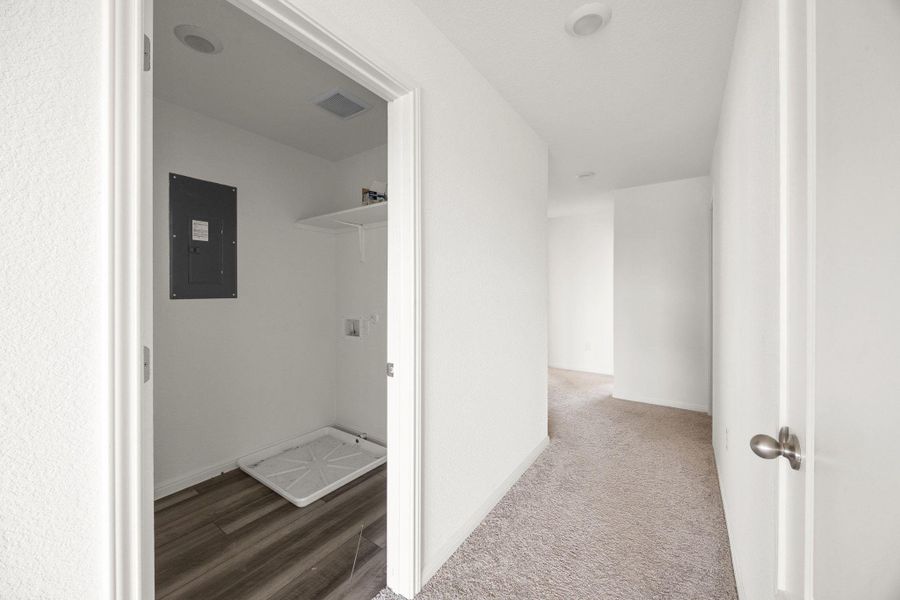 Corridor with electric panel and light colored carpet