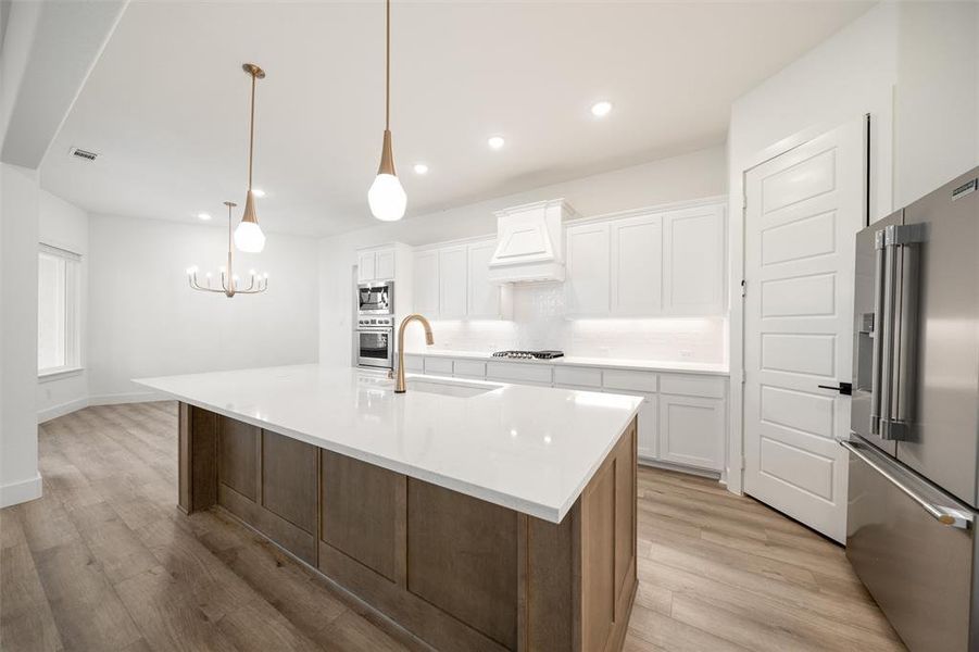 Kitchen with appliances with stainless steel finishes, light wood-type flooring, white cabinetry, and recessed lighting