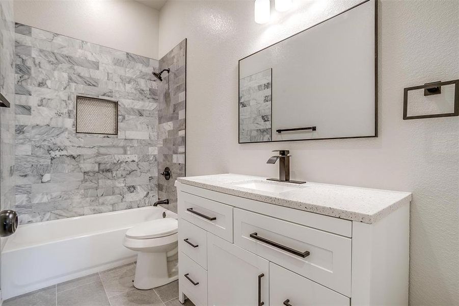 Bathroom featuring vanity, tile patterned flooring, toilet, and shower / washtub combination Bathroom featuring vanity, tile patterned flooring, toilet, and shower / washtub combination
