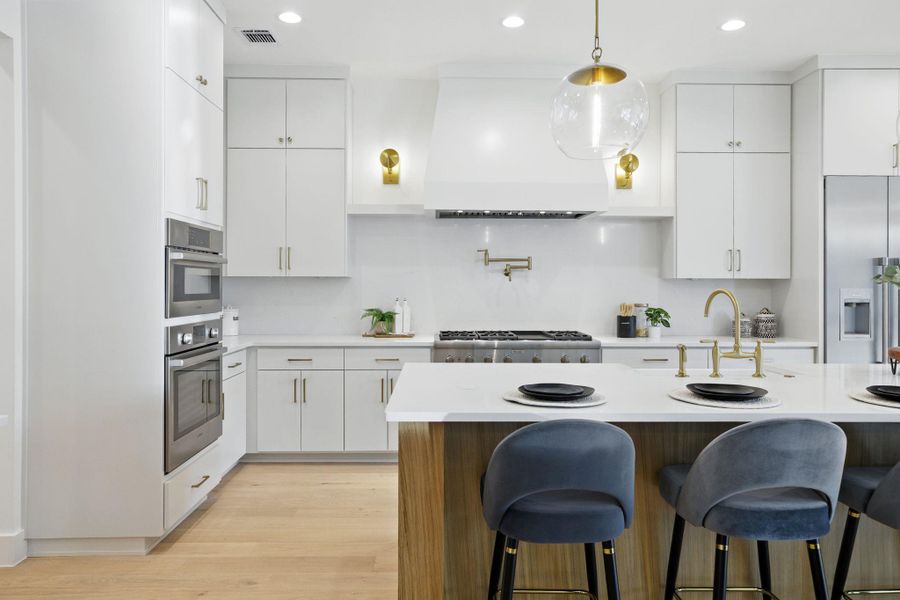 Kitchen with extractor fan, light countertops, a sink, and recessed lighting