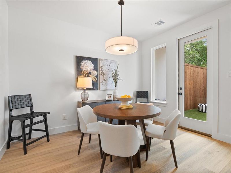 Dining room featuring baseboards, visible vents, and light wood finished floors
