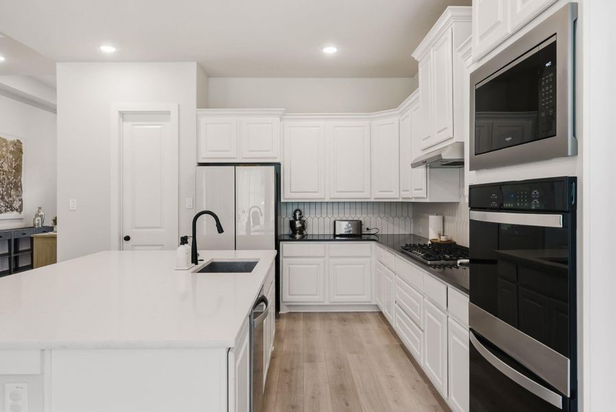 White cabinetry provides an abundance of storage space to keep your countertops completely organized and clutter-free