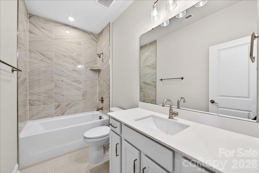Secondary bathroom with tiled walls above the tub