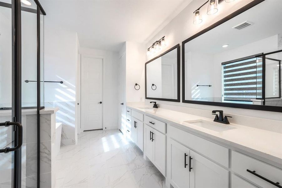 Bathroom featuring a sink, visible vents, marble finish floor, and double vanity