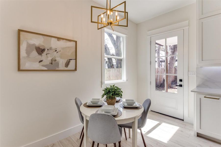 Dining space featuring plenty of natural light, baseboards, light wood-type flooring, and an inviting chandelier