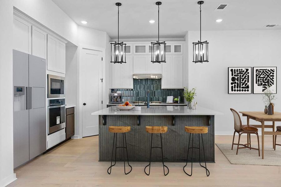 Kitchen with stainless steel oven, built in microwave, refrigerator with ice dispenser, tasteful backsplash, and light wood-type flooring Kitchen with stainless steel oven, built in microwave, refrigerator with ice dispenser, tasteful backsplash, and light wood-type flooring