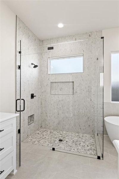 Full bathroom with a stall shower, a freestanding tub, vanity, light tile patterned flooring, and recessed lighting