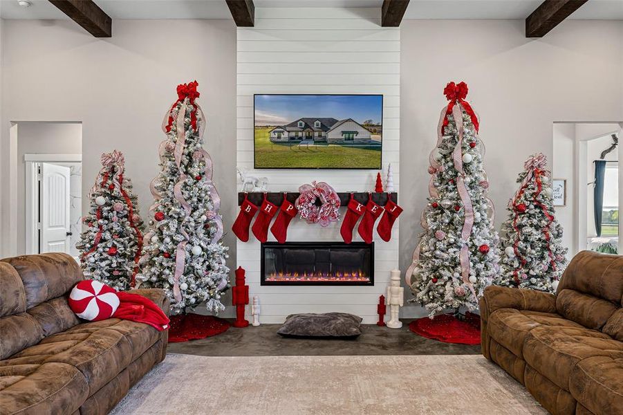 Living room with beamed ceiling, a fireplace, and concrete floors Living room with beamed ceiling, a fireplace, and concrete floors