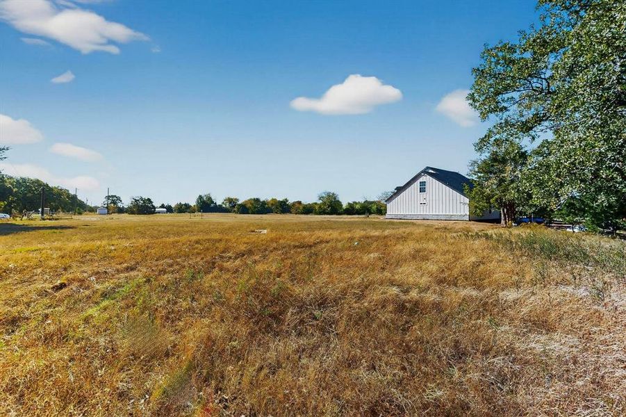 View of yard featuring a rural view and an outbuilding