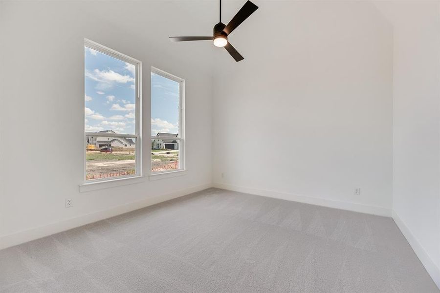 Unfurnished room with light colored carpet and ceiling fan
