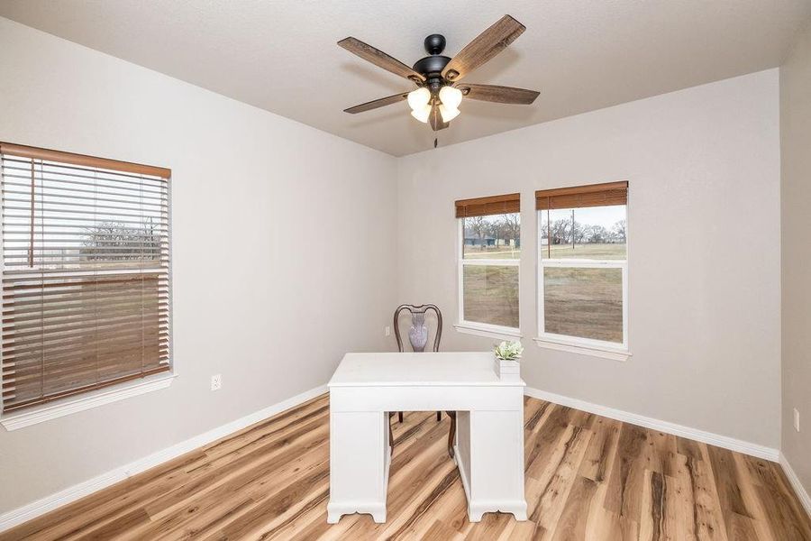 Unfurnished office with ceiling fan, a healthy amount of sunlight, and light hardwood / wood-style floors