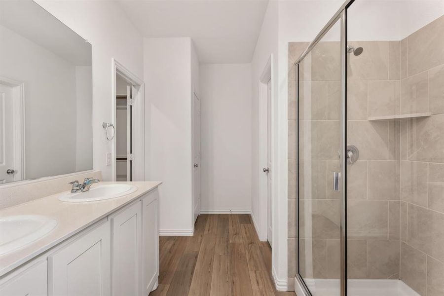 Double vanity, huge shower, walkin closet, and door on water closet.