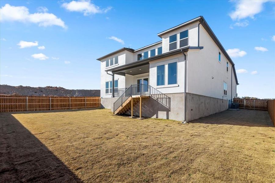 Back of property featuring a fenced backyard and stucco siding