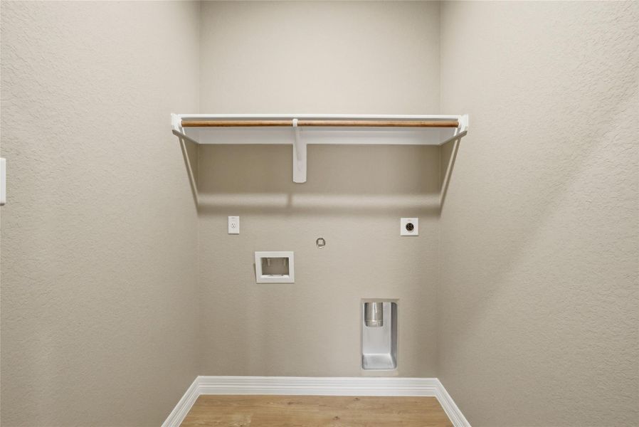 Laundry area with a textured wall, hookup for a gas dryer, light wood-style floors, hookup for an electric dryer, and hookup for a washing machine