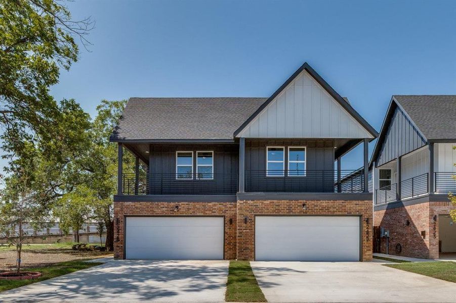 View of front of property with board and batten siding, concrete driveway, brick siding, and an attached garage View of front of property with board and batten siding, concrete driveway, brick siding, and an attached garage