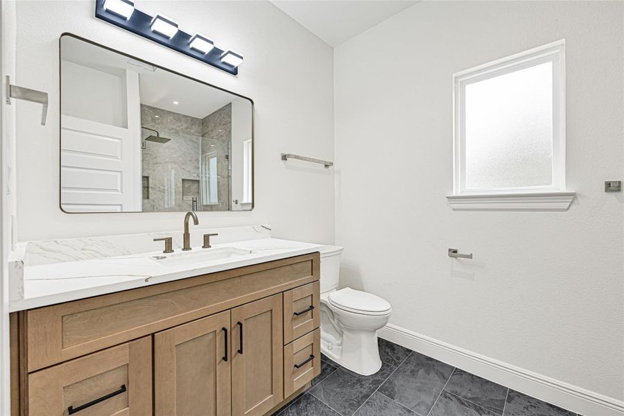 Modern bathroom with a spacious vanity featuring dual sinks and a large mirror. It has a sleek design with neutral tones, a walk-in shower, and ample natural light from a frosted window. Modern bathroom with a spacious vanity featuring dual sinks and a large mirror. It has a sleek design with neutral tones, a walk-in shower, and ample natural light from a frosted window.