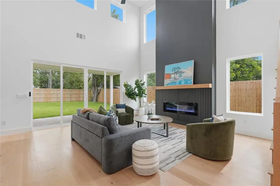 Living area with high ceilings and light wood-finish flooring Living area with high ceilings and light wood-finish flooring