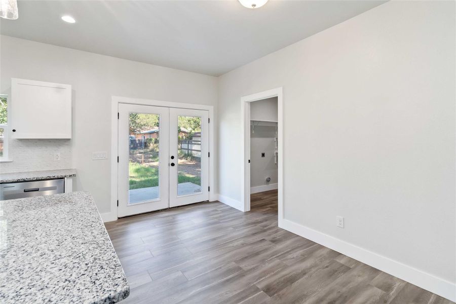 Dining area with french doors, light wood-style floors, and recessed lighting