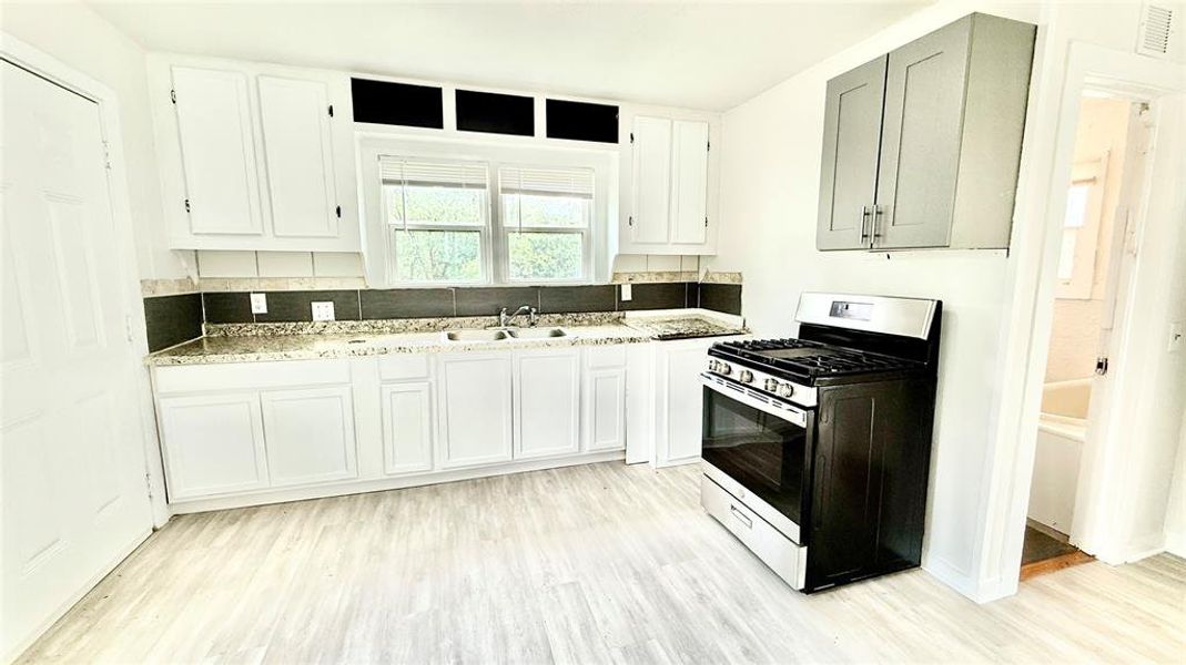 Kitchen with the backdoor on the left and the bathroom on the right.