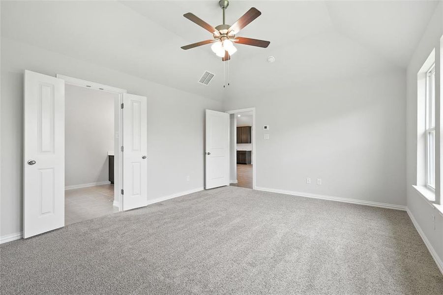 Unfurnished bedroom featuring carpet floors, lofted ceiling, and ceiling fan