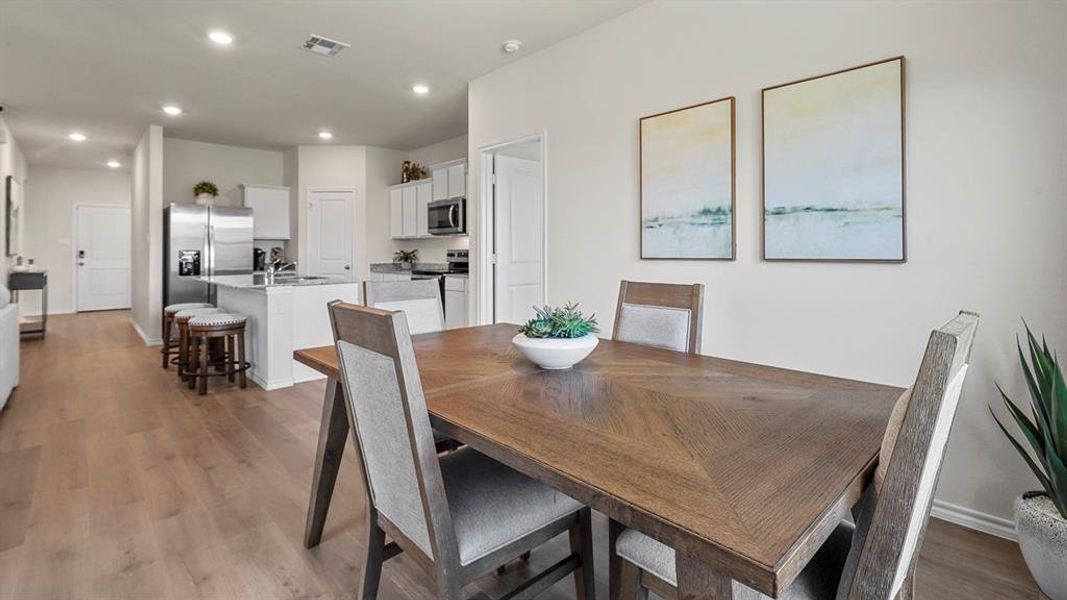 The dining area features hard flooring and an open concept layout with recessed lighting