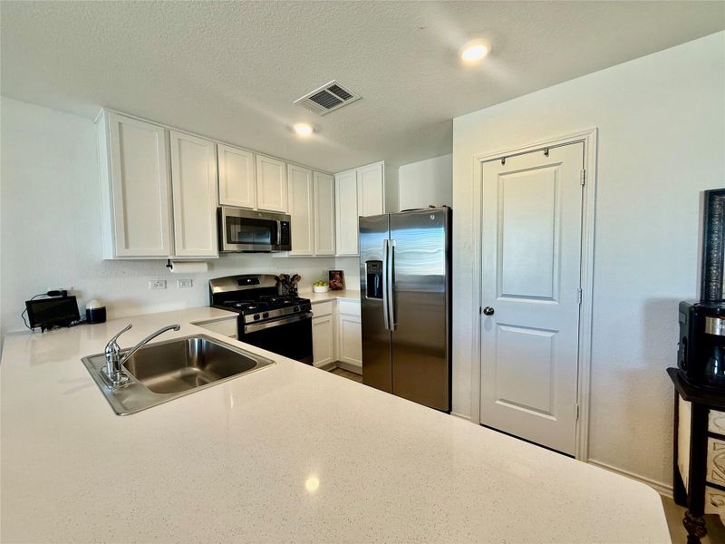 Kitchen featuring white cabinetry, appliances with stainless steel finishes, a textured ceiling, and recessed lighting