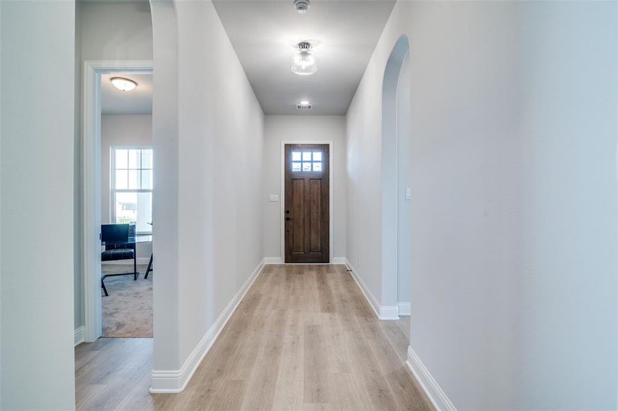 Doorway with a healthy amount of sunlight and light hardwood / wood-style floors