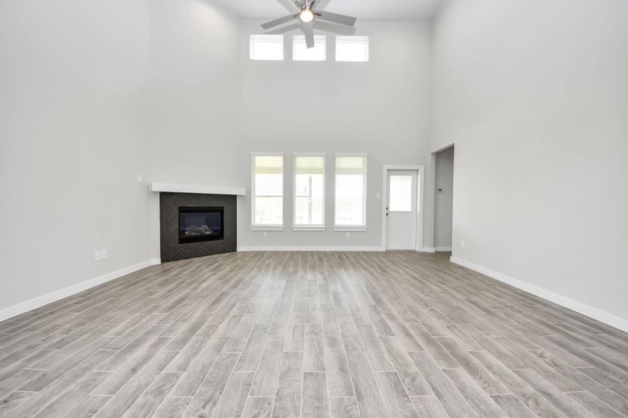 Bring your loved ones and guests together in the inviting living room! Boasting lofty high ceilings, recessed lighting, a stylish ceiling fan, custom paint, stunning flooring, and expansive windows that flood the space with ample natural light all day long. Sample photo of completed home with similar floor plan. Actual colors and selections may vary. Bring your loved ones and guests together in the inviting living room! Boasting lofty high ceilings, recessed lighting, a stylish ceiling fan, custom paint, stunning flooring, and expansive windows that flood the space with ample natural light all day long. Sample photo of completed home with similar floor plan. Actual colors and selections may vary.
