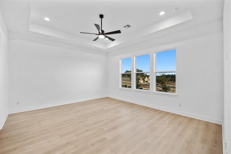Unfurnished primary room with a ceiling fan, light wood-style flooring, and recessed lighting