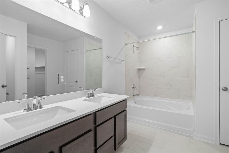 This primary bathroom is definitely move-in ready! Featuring an oversized tub/shower combo with tile surround, stained cabinets with light countertops, high ceilings, neutral paint, sleek and modern finishes.