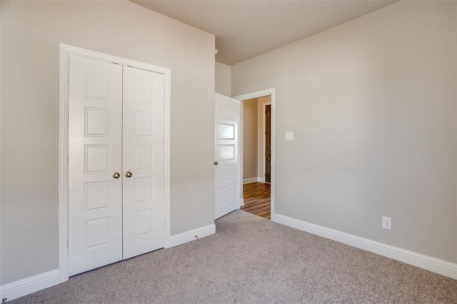 Unfurnished bedroom featuring light colored carpet and a closet Unfurnished bedroom featuring light colored carpet and a closet