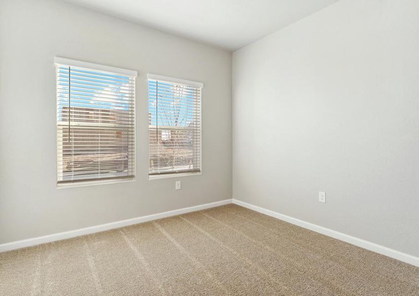 The secondary bedroom has carpet and large windows.