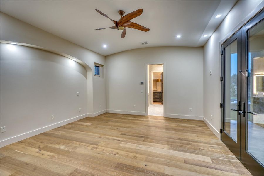 Very spacious primary bedroom with gleaming hardwood floors.