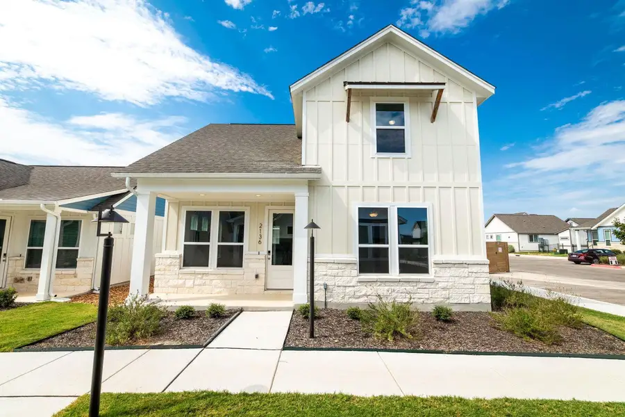 Board and batten siding pairs beautifully with stone accents on this modern exterior. Board and batten siding pairs beautifully with stone accents on this modern exterior.