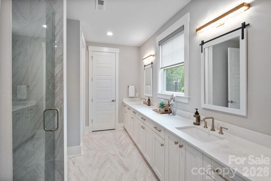 Large Primary Bathroom has dual vanities, quartz counters and large walk-in shower.