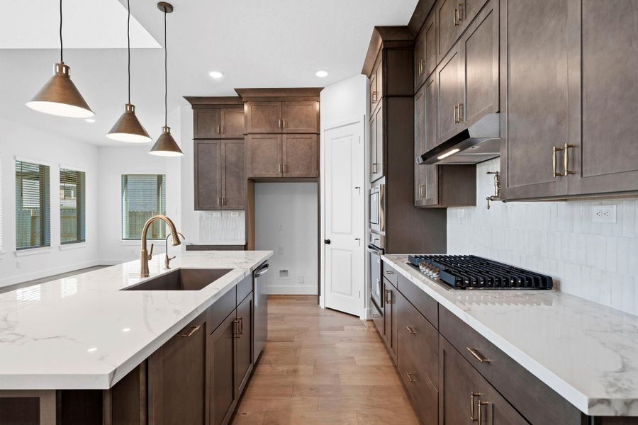 Porcelain counters and champagne gold accents give this popular area a custom look not to mention the pot filler.