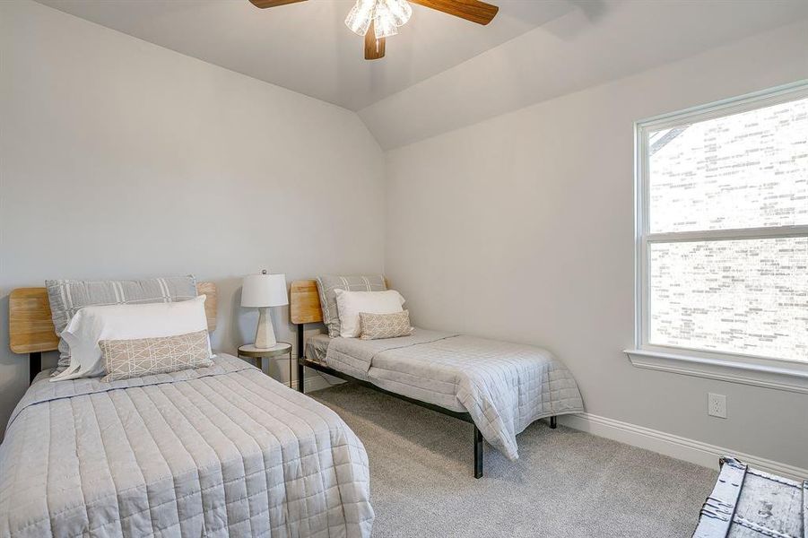 Bedroom with carpet floors, vaulted ceiling, and ceiling fan