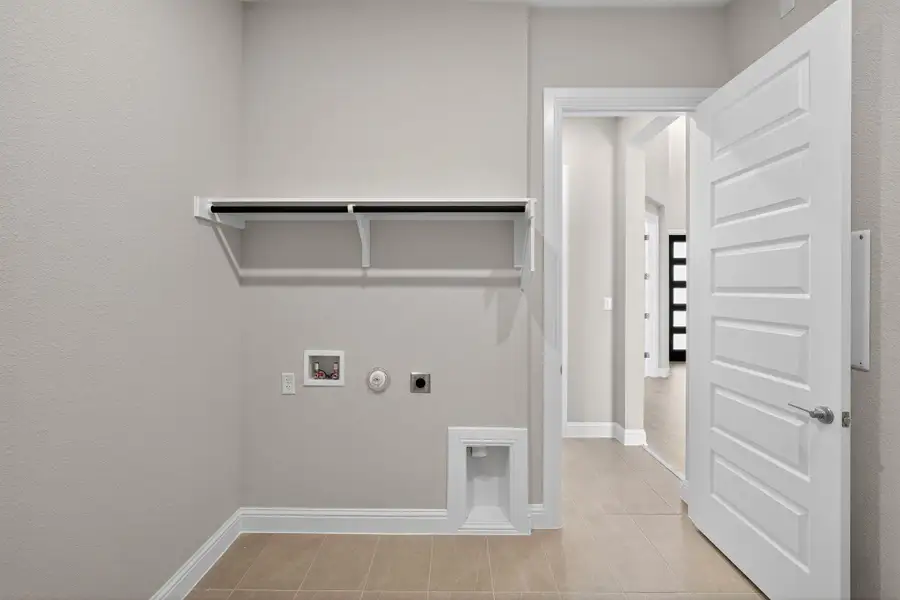 Washroom with hookup for a gas dryer, hookup for an electric dryer, washer hookup, and light tile patterned floors Washroom with hookup for a gas dryer, hookup for an electric dryer, washer hookup, and light tile patterned floors