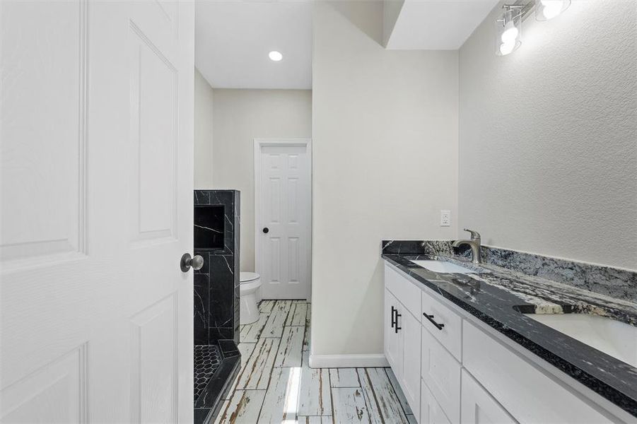 Bathroom featuring double vanity and a shower Bathroom featuring double vanity and a shower