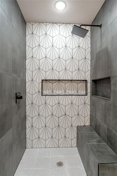 Bathroom with a textured ceiling and tiled shower