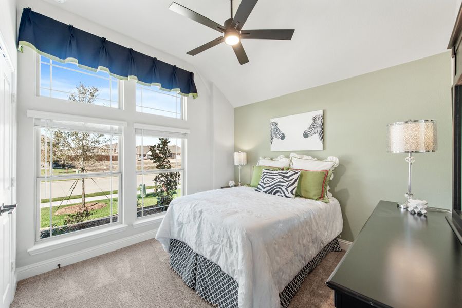 Bedroom with vaulted ceiling, ceiling fan, large windows, and green accent walls Bedroom with vaulted ceiling, ceiling fan, large windows, and green accent walls