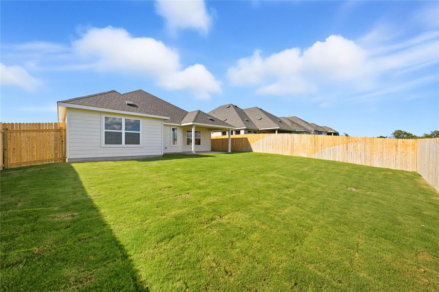 Rear view of property featuring a patio area, a fenced backyard, and roof with shingles Rear view of property featuring a patio area, a fenced backyard, and roof with shingles