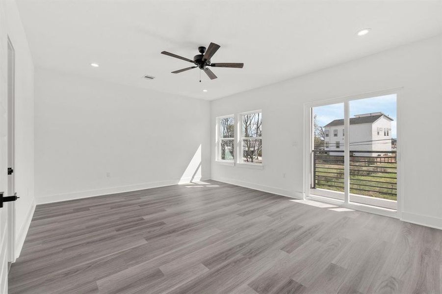 A flood of natural light pours into the master bedroom through big windows and sliding doors that open to the balcony.