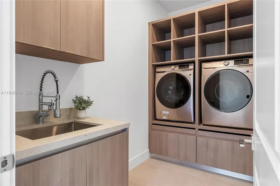 LAUNDRY ROOM with Samsung MultiSteam SmartThings washer and dryer, custom cabinetry, laundry tub, a fenced yard.