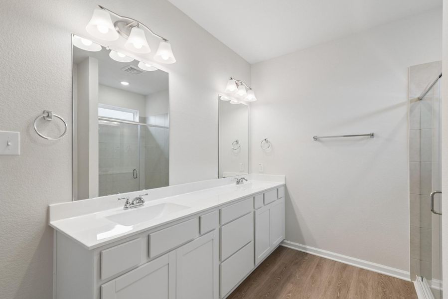The Oakshire II- Primary Bathroom with Dual Vanities and Walk-In Shower.