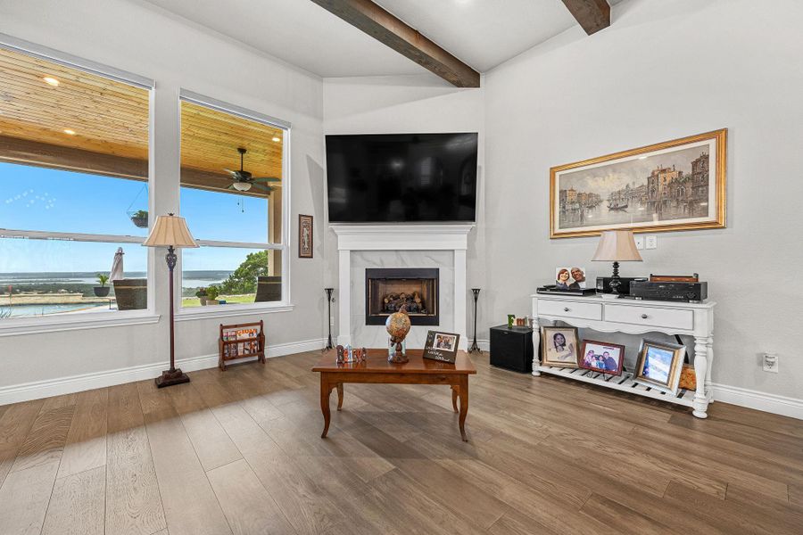 A spacious great room with vaulted beamed ceilings and expansive windows offers natural illumination and scenic vistas. A spacious great room with vaulted beamed ceilings and expansive windows offers natural illumination and scenic vistas.