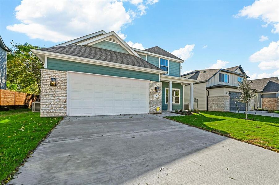 View of front of property with a garage and a front lawn